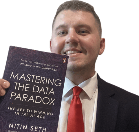 Jake Byford holding the book Mastering the Data Paradox