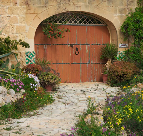 Doubled width arched door in a traditional limestone building. 