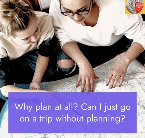 2 women studying a map on a floor & a sign that says 'Why plan at all?'