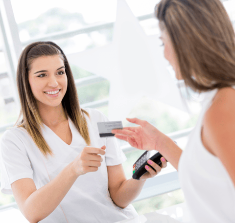 a woman is holding a credit card for a treatment at the salon