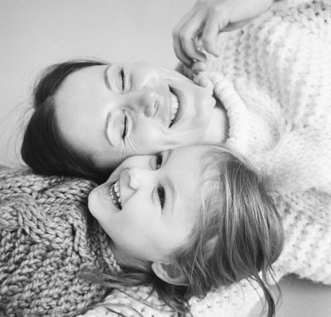 woman lying beside child and smiling