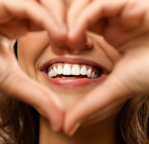 Person smiling confidently after a comprehensive smile makeover, featuring perfectly aligned and bri