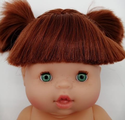 a Minikane baby doll with red hair and green eyes