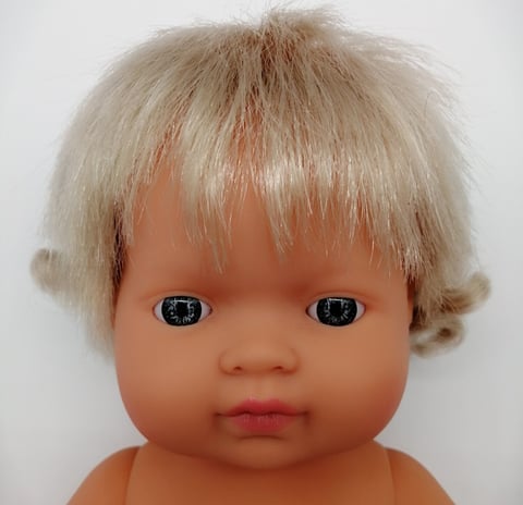 a Miniland baby doll with blonde hair and blue eyes