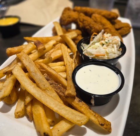 image of french fries, ranch, coleslaw, and chicken fingers from AppleBee's