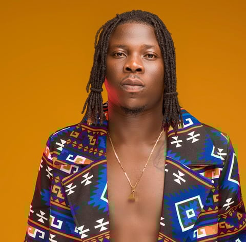Stonebwoy in a material dress.