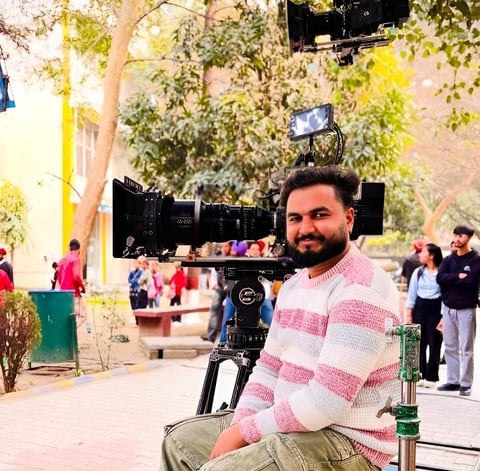 sukhvinder singh sitting on a bench in front of a camera