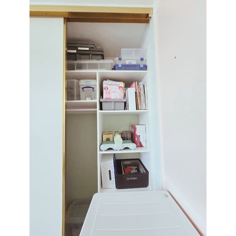 The transformed cupboard with organised shelves and labelled storage boxes