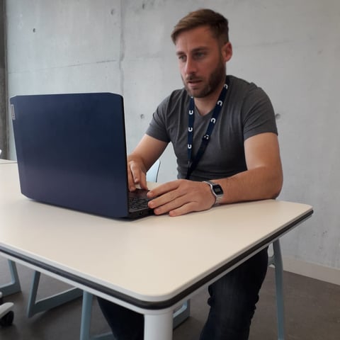 Informaticien entrain de travailler positionné devant son ordinateur 