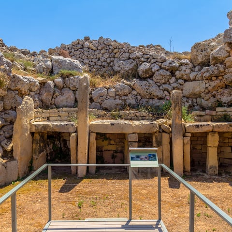 Ggantija Temples. A semi-circle limestone rubble wall surrounds three altar slabs.