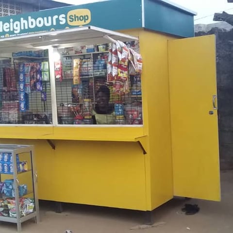 Woman entrepreneur inside of a Neighbours Shop solar-powered kiosk in Lagos.