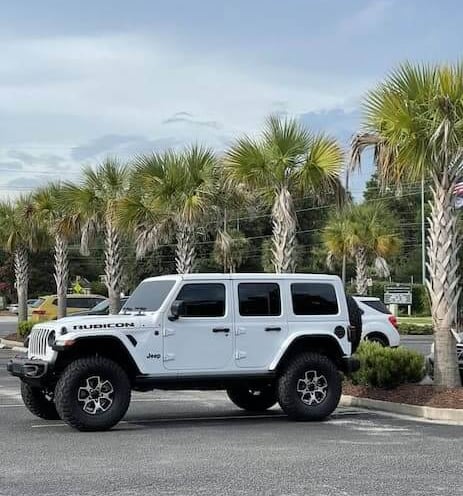 Vehículo blanco tipo Jeep estacionado en exterior listo para servicio de detallado móvil.