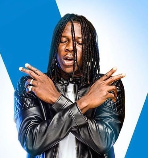 Stonebwoy in a black leather dress.