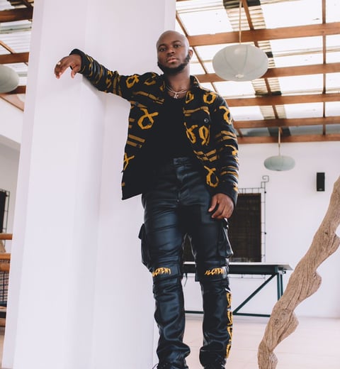 King Promise in a black shirt and black trousers.