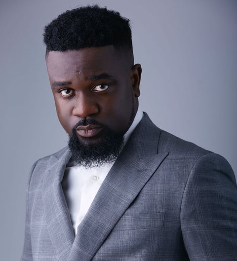 Sarkodie in a silky ash suit.