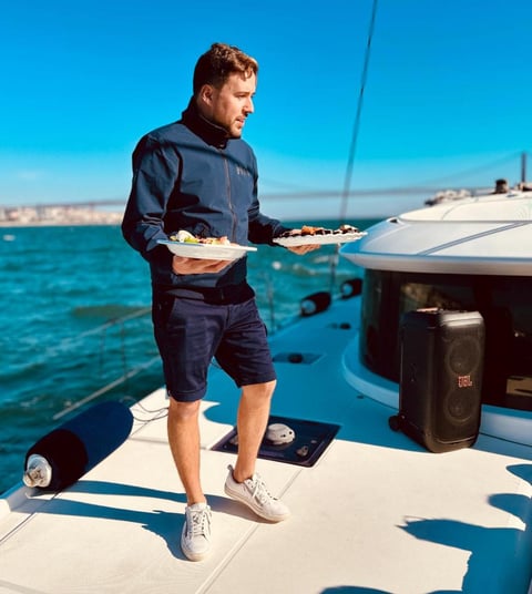 Notre Capitaine proposant des sushis à nos invites lors d'une balade en bateau sur notre catamaran L