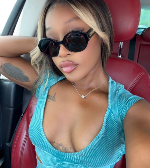 Efia Odo in a car wearing black sunglasses.