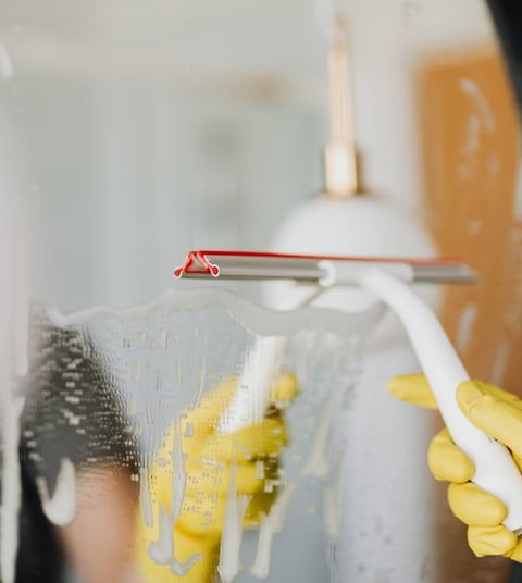 wiping mirror during home cleaning service