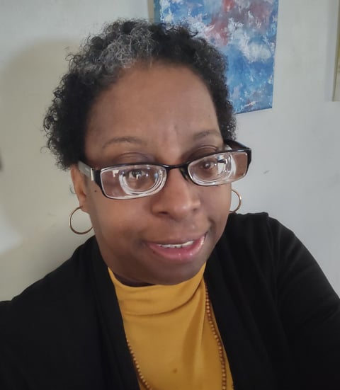 Image of Traci Joy smoling and facing the camera.