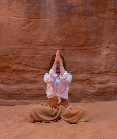 a woman in a white shirt and pants is doing yoga
