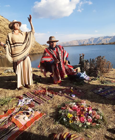 a medicine woman and a medicine man in a Despacho ceremony praying with the spirits of the mountain