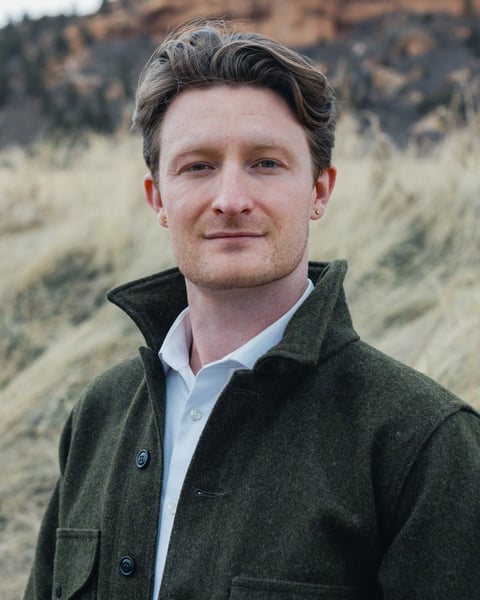 tristan lyons wearing a green jacket and a white shirt, looking directly at the camera