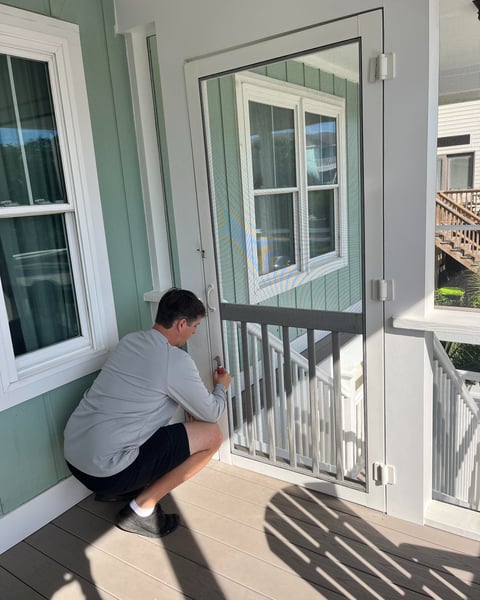 Technician rescreening a door with fiberglass screen. 