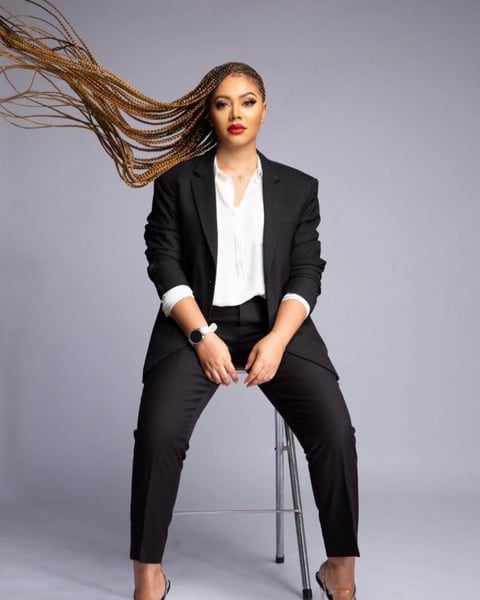 Nadia Buari in a black top and trousers with a white inner shirt.