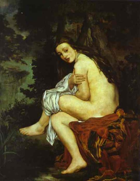 a naked woman sitting on a blanket in a wooded area