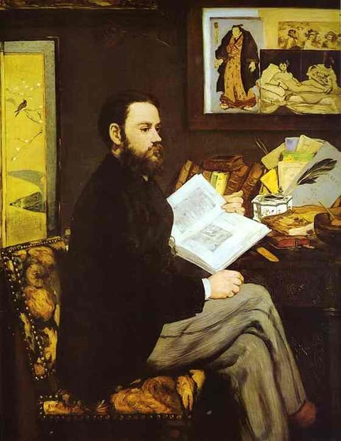 a man sitting at a desk with a book and a book