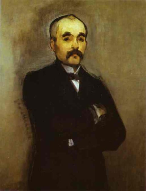 a man in a suit and tie is standing in front of a wall