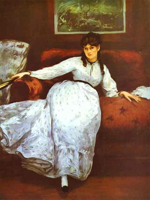 a woman in a white dress sitting on a couch