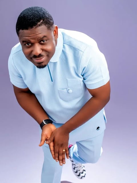 Nacee dressed in a silky blue shirt.
