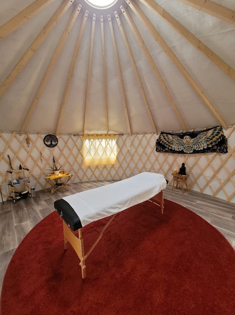 intérieur de la yourte du Chemin de la Chouette avec table de soin