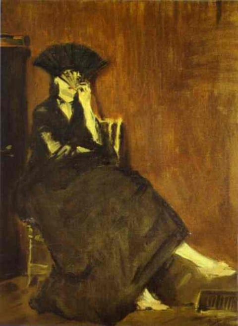 a woman in a black dress sitting on a chair