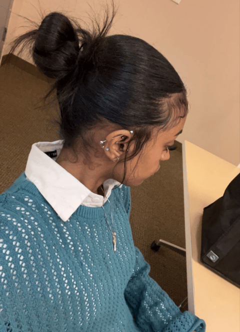 a young girl sitting at a desk with a laptop. slick hair