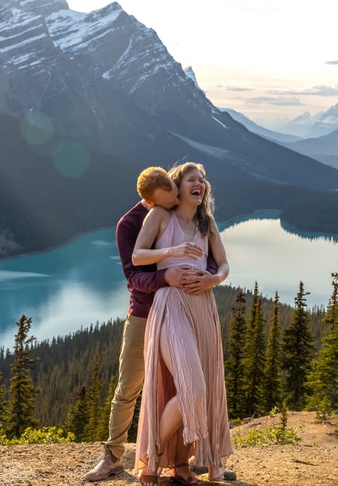 Guy hugging girl from behind at peyto lake