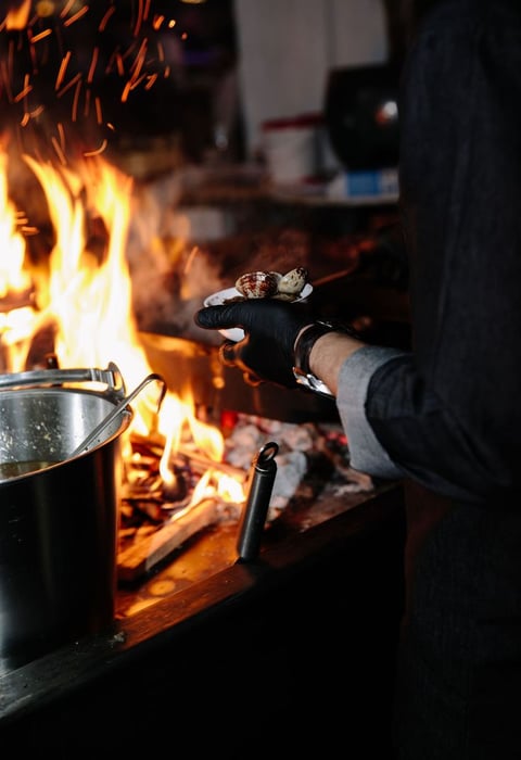 a person cooking food in a potted potted on a stove