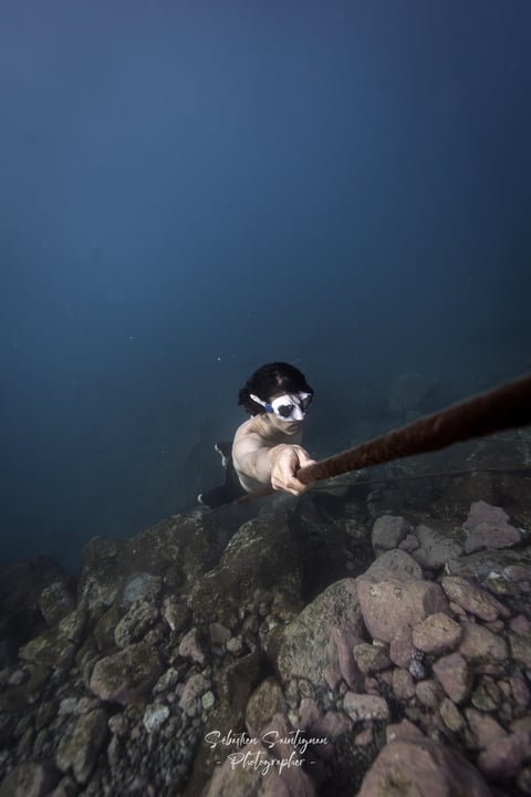 a model holding a rope during underwater photoshoot. Photo taken by Sébastien Saintignan