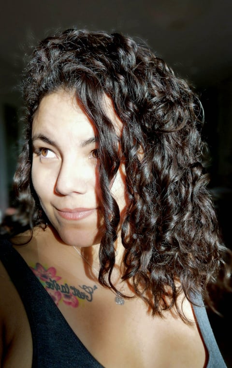 Portrait de Suzi Santana, regard éveillé et tatouage de rose, symbole de reconnaissance intuitive