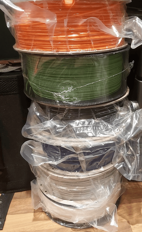 A selection of 3D printer filament reels in a range of colours