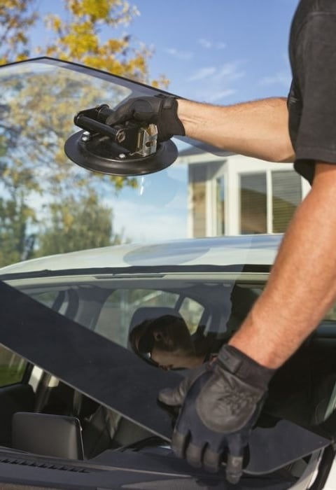 a man in a black shirt is holding a WINDSHEILD