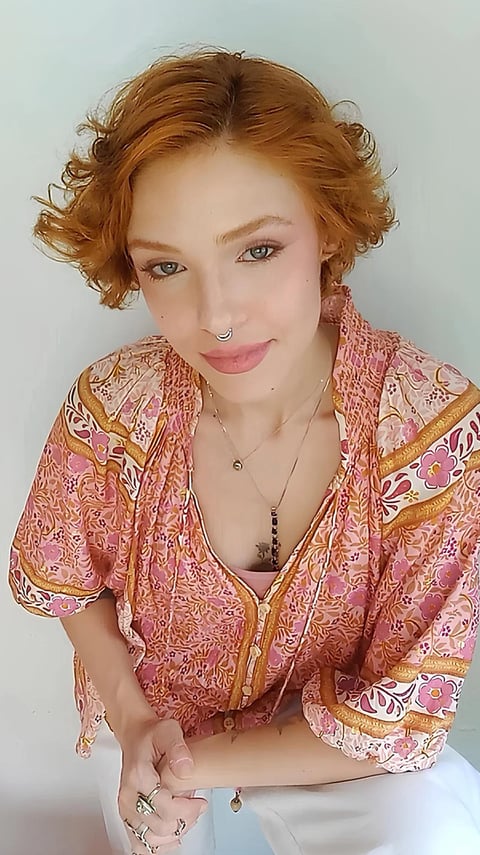 Sabrina Tibursky com um olhar compreensivo e mãos próximas sobre a coxa