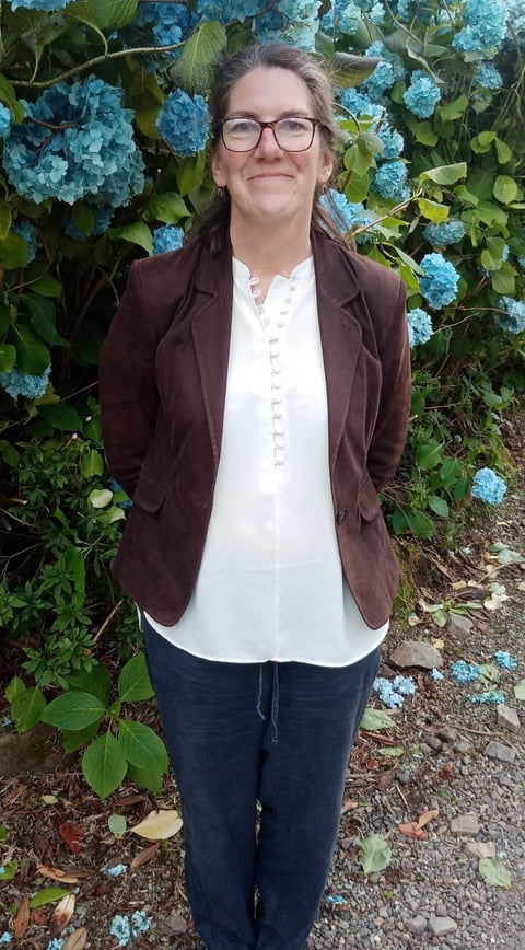 Picture of Jenny Leeder with flowers behind her