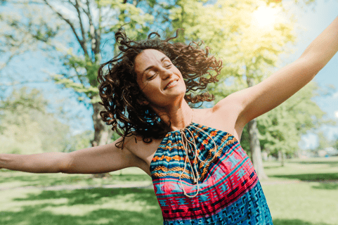 a woman with her arms outstretched out and arms outstretched out, smiling and holding a