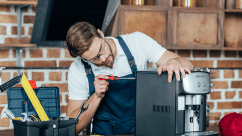 a man in a blue apron and glasses is working on a computer