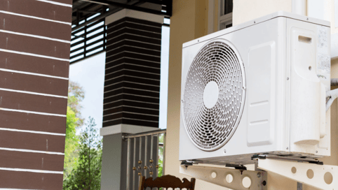 a white air conditioner sitting on a chair