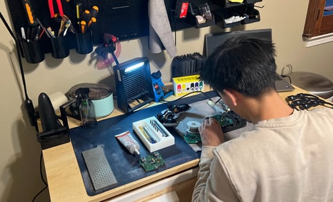 Joshua Lu working on repair a gaming controller for his business venture online.