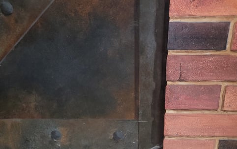 Détail d'un décor peint en trompe-l'oeil, imitation de métal rouillé et mur de briques
