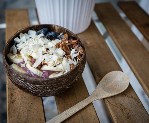 a bowl of fruit and nuts on a wooden table